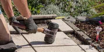 A,Professional,Paver,Worker,Laying,Patio,Slabs,In,A,Gravel