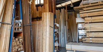 Interior view of a timber merchant's warehouse storing a large selection of various types and sizes of prepare wood for sale.