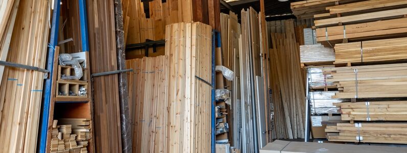 Interior view of a timber merchant's warehouse storing a large selection of various types and sizes of prepare wood for sale.